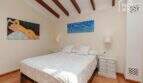 Helles Schlafzimmer der mallorquinischen Villa in Lloseta mit Doppelbett, Holzbalkendecke und mediterranem Flair.