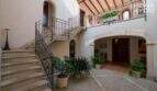 Innenhof der mallorquinischen Villa in Lloseta mit Steintreppe, Schmiedeisengeländer und mediterranen Pflanzen.