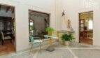 Innenpatio der mallorquinischen Villa in Lloseta mit bunten Stühlen, Pflanzen und Blick in Wohn- und Esszimmer.