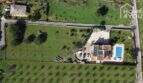 Luftaufnahme mallorquinischer Villa in Lloseta mit Pool, Solaranlage, Obstgarten und großem Grundstück.
