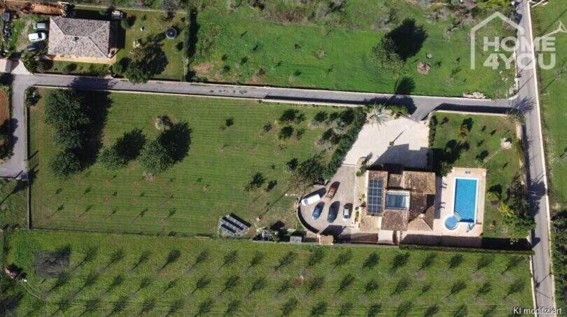 Luftaufnahme mallorquinischer Villa in Lloseta mit Pool, Solaranlage, Obstgarten und großem Grundstück.