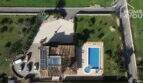 Luftaufnahme der mallorquinischen Villa in Lloseta mit Salzwasserpool, Solarpanelen und großem Grundstück.