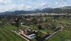 Luftaufnahme: Mallorquinische Villa mit Salzwasserpool, Garten und Blick auf Lloseta und Tramuntana-Gebirge.