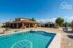 Mediterranean finca in Santa Margalida: Exterior view with pool, terrace and garage under blue sky.