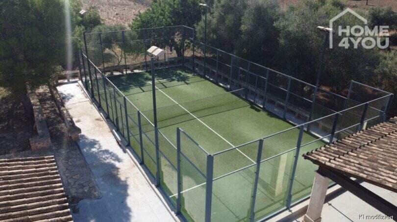 Pista de pádel privada con césped artificial y valla de metal de la finca mediterránea en Santa Margalida