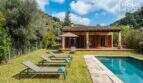 Finca Campanet: Außenpool mit Liegestühlen, Terrasse und mediterranem Landhaus inmitten grüner Natur.
