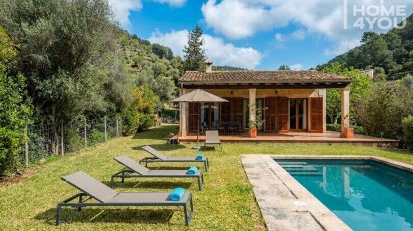 Finca Campanet: Außenpool mit Liegestühlen, Terrasse und mediterranem Landhaus inmitten grüner Natur.