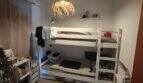 Children's room with white bunk bed, wooden beam ceiling, pendant light and bookshelf in finca near Felanitx