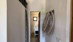 Narrow hallway with wooden beam ceiling, leading to bathroom, wardrobe with macramé wall decoration, Finca Felanitx