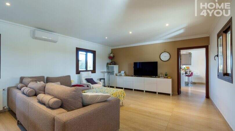 Helles Wohnzimmer der Finca in Santa Margalida mit Sofa, TV, Klimaanlage und Holzboden.