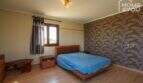 Schlafzimmer mit Doppelbett, Holzboden, dekorativer Tapetenwand und Fenster in moderner Finca, Santa Margalida