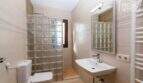 Helles Badezimmer der Finca mit Glasbausteindusche, WC, Waschtisch und Handtuchheizkörper.