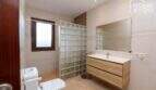 Modernes Badezimmer der Finca in Santa Margalida mit Glasbausteindusche, Holzwaschtisch und großem Spiegel.