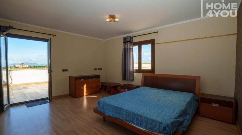 Helles Schlafzimmer mit Doppelbett, Holzboden, Terrassenzugang und Bergblick in moderner Finca, Santa Margalida.