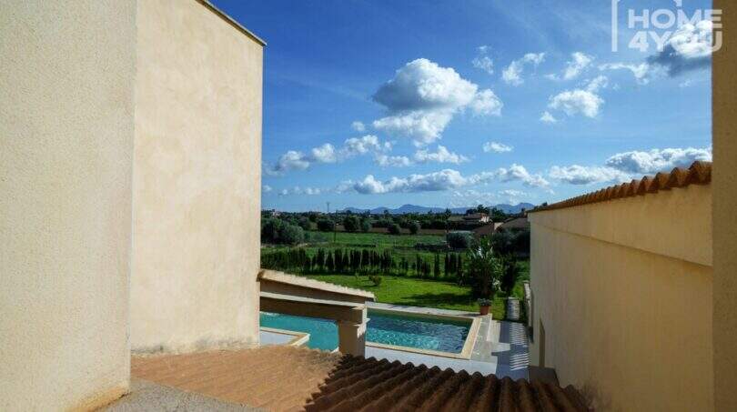 Blick vom Obergeschoss auf Pool, grünen Garten und Felder der modernen Finca in Santa Margalida