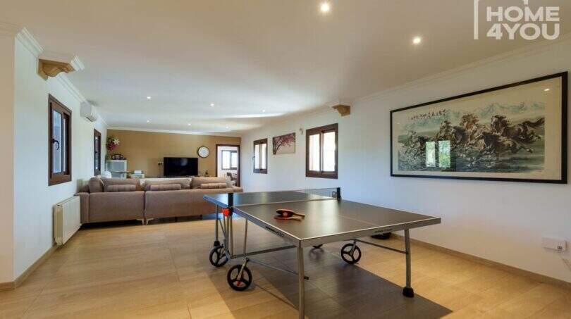 Geräumiger Freizeitraum mit Tischtennisplatte, Sofa-Lounge und TV-Bereich in moderner Finca, Santa Margalida.