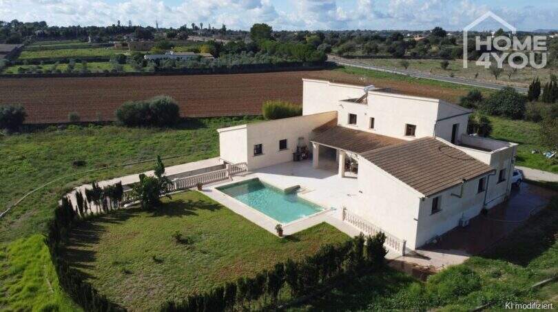 Luftaufnahme moderner Finca in Santa Margalida mit Pool, weitläufigem Grundstück und Blick auf umliegende Felder.