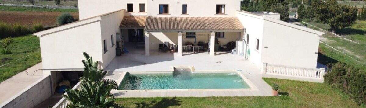 Luftaufnahme der modernen Finca in Santa Margalida mit Pool, Terrasse, weitläufigem Garten und Bergblick.