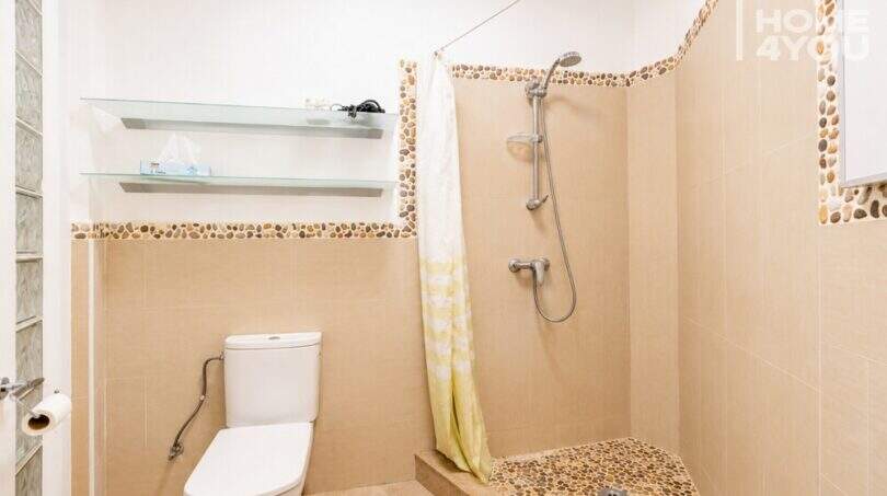Baño moderno con ducha, WC y mosaico de guijarros en apartamento cerca del mar en Ses Salines