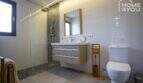 Baño moderno de la finca con ducha a ras de suelo, lavabo de madera e inodoro