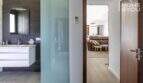 Baño moderno de la finca en Sa Pobla con lavabo, puerta corredera y vista a la sala de estar