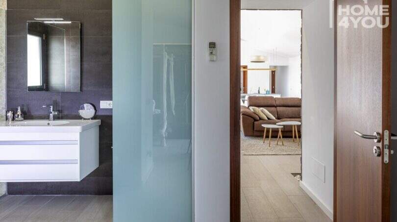Baño moderno de la finca en Sa Pobla con lavabo, puerta corredera y vista a la sala de estar