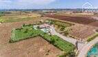 Vista aérea finca mediterránea Sa Pobla: casa principal, casa de huéspedes, piscina, jardín cuidado, parcela de 24.000 m²