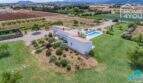 Vista aérea finca moderna mediterránea Sa Pobla: casa de techo plano blanca, piscina panorámica, jardín cuidado, parcela de 24.000 m²