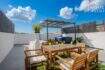 Roof terrace with wooden furniture, Jacuzzi under pergola and orange juice glasses, Maria de la Salut townhouse