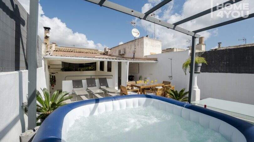 Dachterrasse mit aufblasbarem Jacuzzi, Liegestühlen und Esstisch unter Pergola in Stadthaus Maria de la Salut