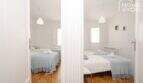 Zwei helle Schlafzimmer mit blauen Tagesdecken, Pendelleuchten und Terrakottaboden im Stadthaus Maria de la Salut