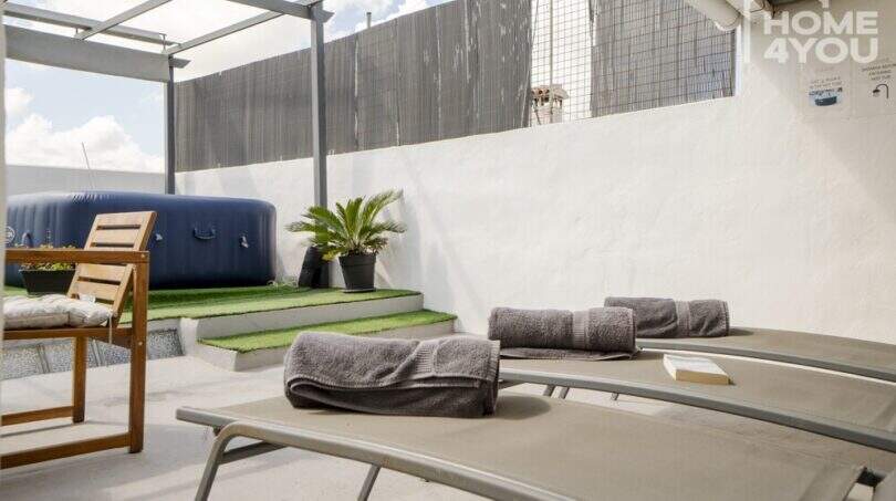 Sonnige Dachterrasse mit Liegestühlen, Jacuzzi und Pergola des Stadthauses in Maria de la Salut