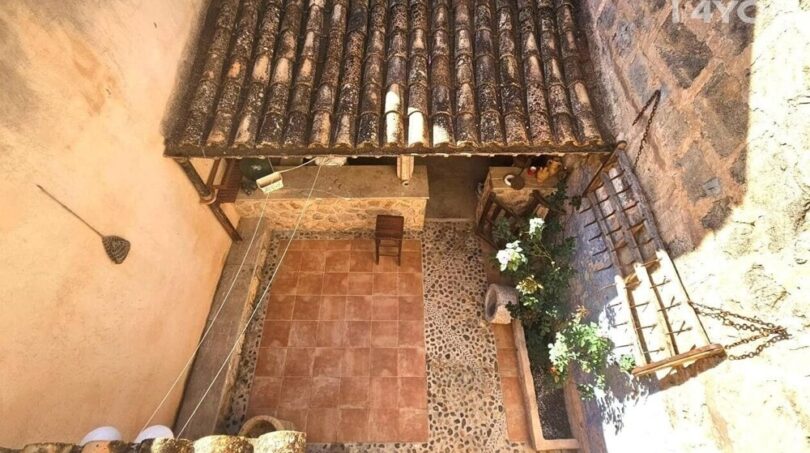 Innenhof von oben mit Terrakottafliesen, Natursteinmauern und traditionellen Dachziegeln, Stadthaus Petra Mallorca