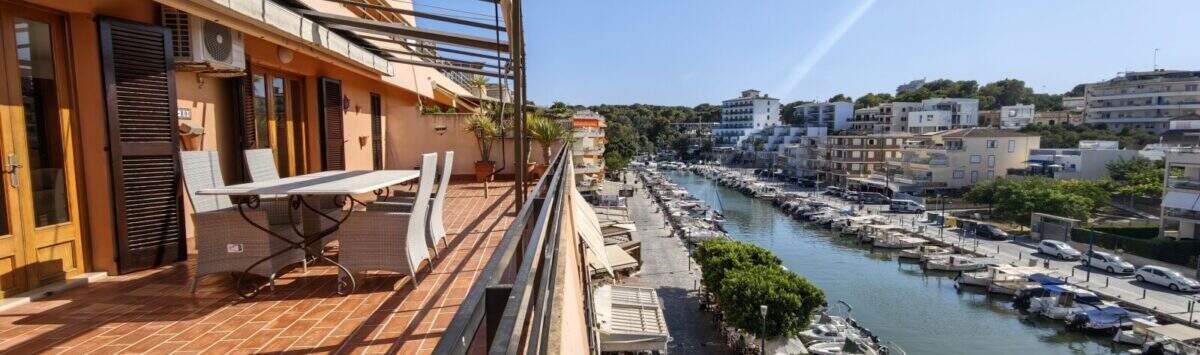 Sonnige Dachterrasse mit Sitzgruppe und direktem Blick auf den Hafen von Porto Cristo mit Booten