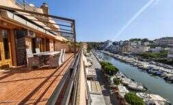 Soleada terraza en la azotea con zona de estar y vista directa al puerto de Porto Cristo con barcos