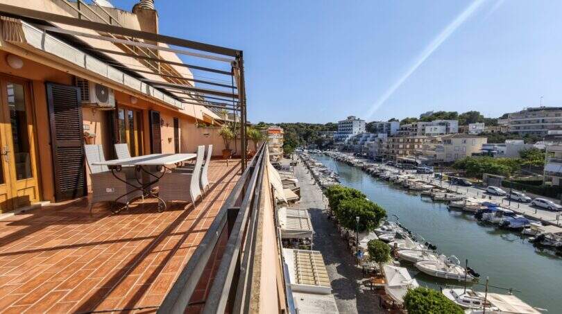 Sonnige Dachterrasse mit Sitzgruppe und direktem Blick auf den Hafen von Porto Cristo mit Booten