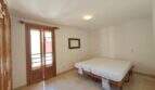 Helles Schlafzimmer mit zwei Einzelbetten, Balkon mit Holztüren und Wandspiegel in Hafenwohnung Porto Cristo
