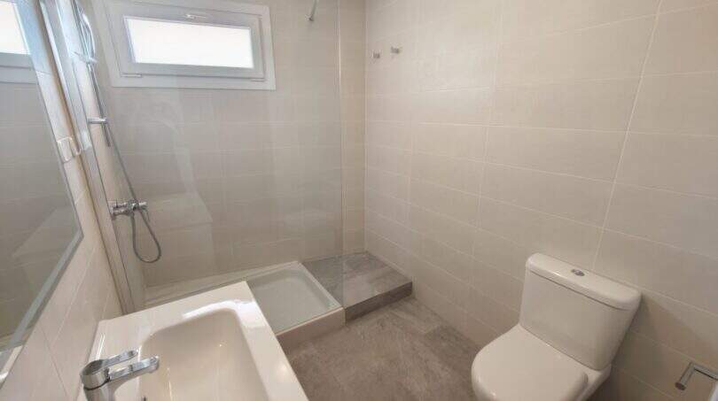Modernes Badezimmer mit Dusche, WC und Waschbecken in der Hafenwohnung 1. Linie Porto Cristo