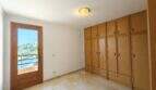 Helles Schlafzimmer mit großem Holzeinbauschrank, Balkonzugang und Meerblick in Porto Cristo