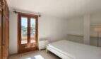 Helles Schlafzimmer mit Doppelbett, Holzschrank und Terrassentür mit Meerblick in Porto Cristo