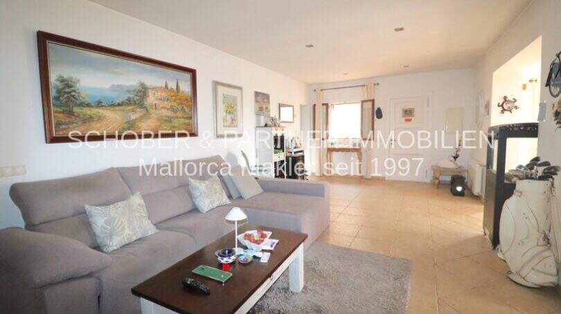 Bright living room with gray sofa, coffee table, fireplace and Mediterranean painting in Son Servera