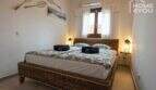 Schlafzimmer mit Doppelbett aus Rattan, Klimaanlage und warmer Beleuchtung im Bungalow in Alcúdia