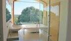 Luxusbad der Finca Felanitx mit freistehender Badewanne, Glasdusche und Panoramafenster mit Naturblick