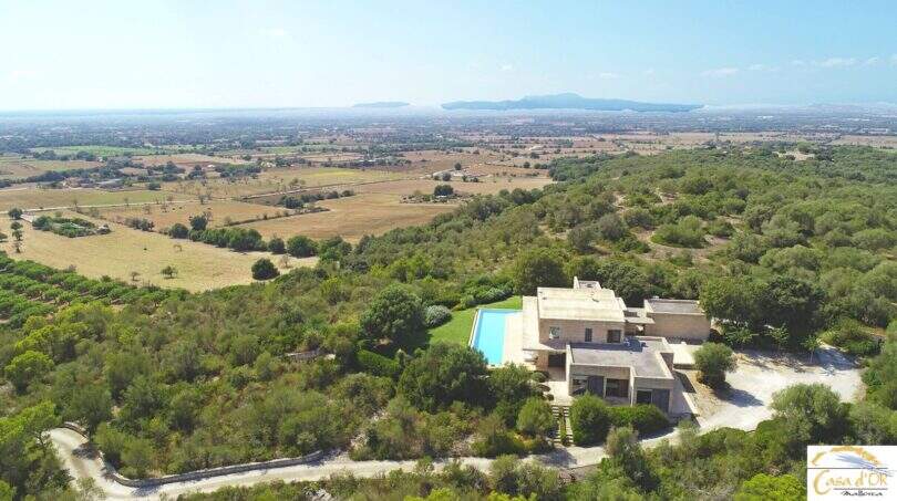 Luftaufnahme moderner Finca in Felanitx mit Infinity-Pool, Garten und Panoramablick über die mallorquinische Landschaft.