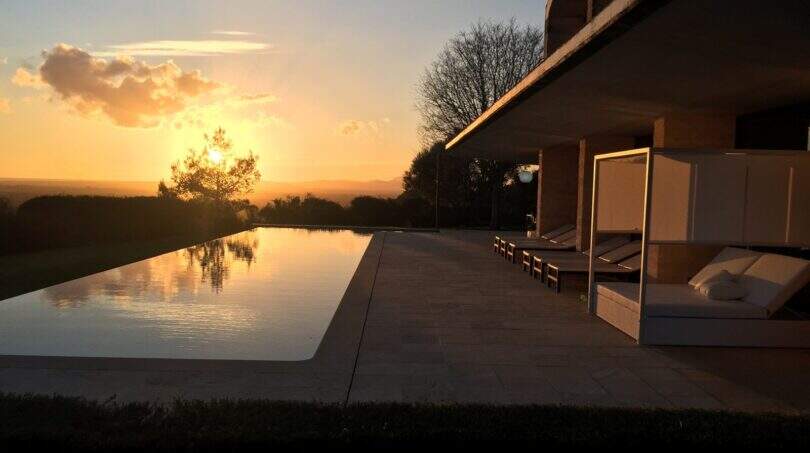 Infinity-Pool mit Sonnenuntergang und Liegestühlen der modernen Finca mit Weitblick in Felanitx