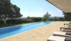 Infinity-Pool mit Natursteintetrasse, Liegestühlen und Weitblick über die Landschaft von Felanitx