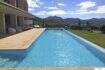 Großer Infinity-Pool mit Sandsteintetrasse, Loungebereich und Bergpanorama der modernen Finca in Felanitx