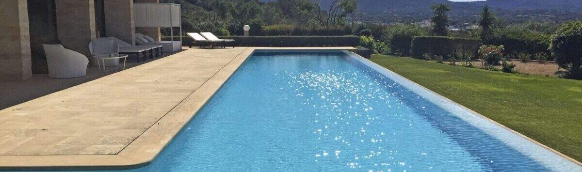 Großer Infinity-Pool mit Sandsteintetrasse, Loungebereich und Bergpanorama der modernen Finca in Felanitx