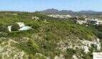 Luftaufnahme moderne Finca Felanitx mit Infinity-Pool, umgeben von grüner Landschaft und Blick auf Berge