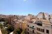 Panoramablick über die Altstadt von Palma de Mallorca mit historischen Gebäuden und Terrakotta-Dächern bei blauem Himmel.